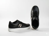 Black sneakers with a text "N"