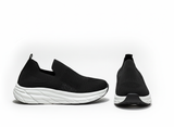 Black slip-on sneakers with white soles